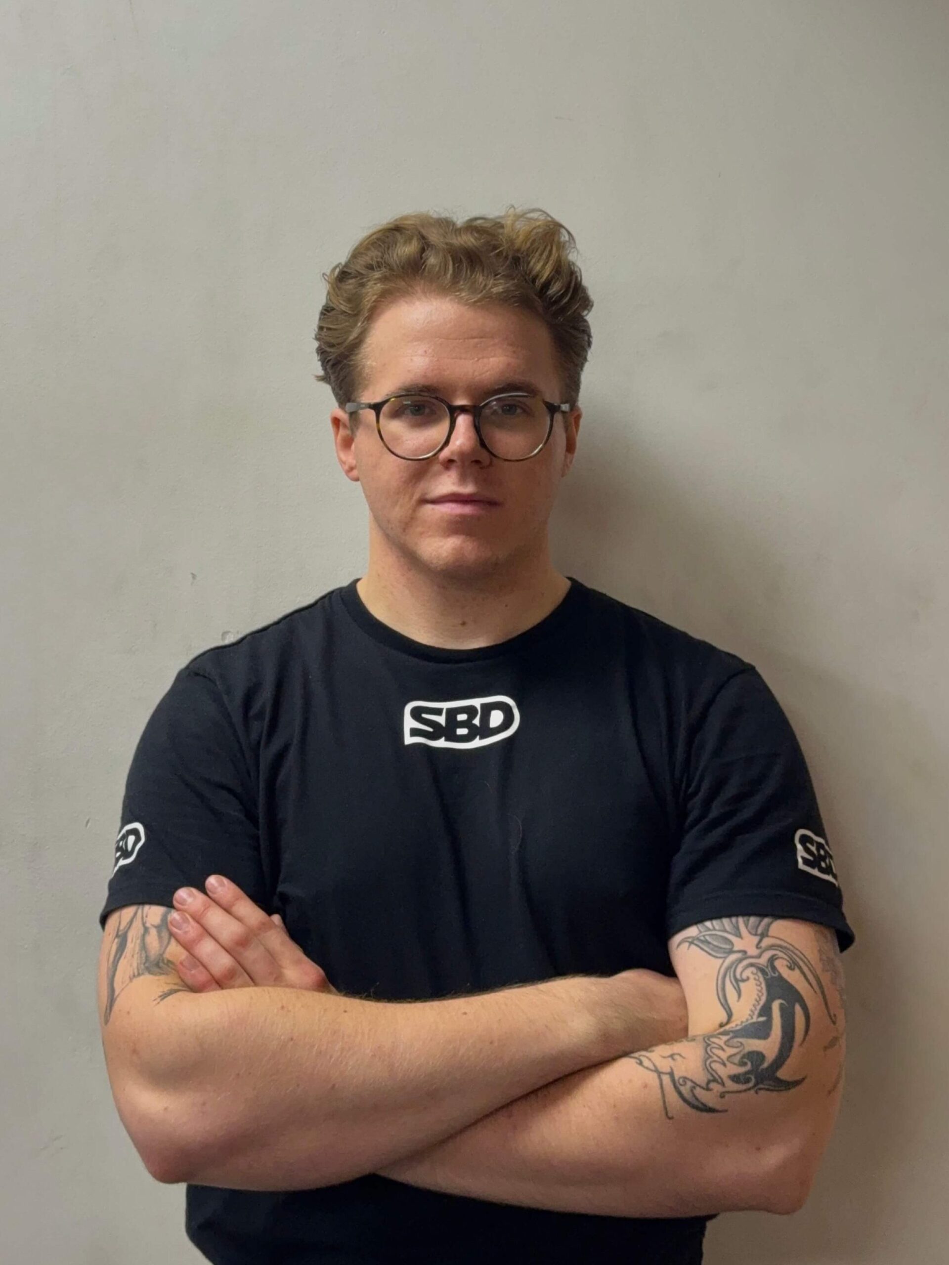 Trener personalny na tle szarej ściany